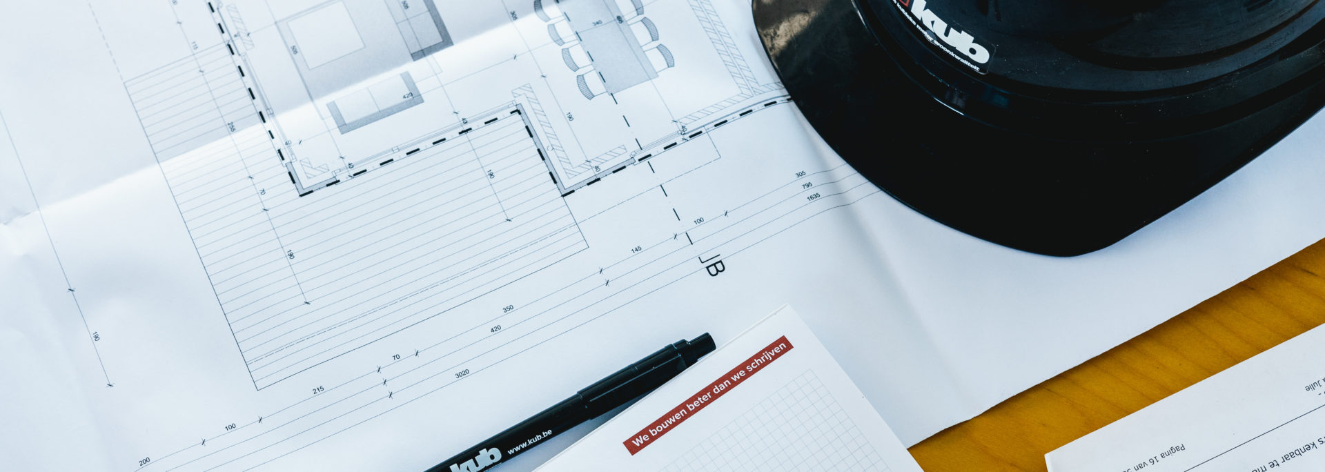 Bouwdocumenten van KUB op tafel tijdens projectvoorbereiding in Waregem