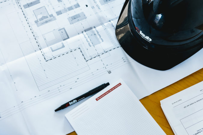 Bouwdocumenten van KUB op tafel tijdens projectvoorbereiding in Waregem