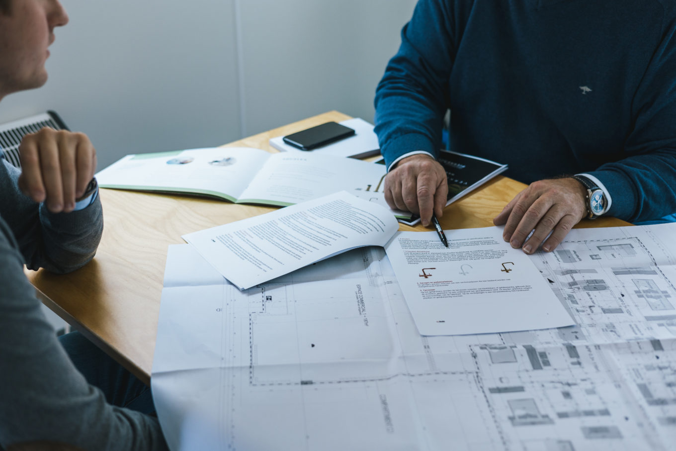 Bouwdocumenten van KUB op tafel tijdens projectvoorbereiding in Waregem
